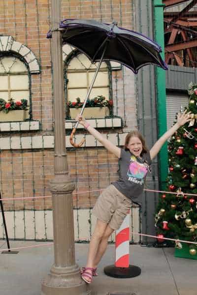 girl at Disney during Christmas with tree in background
