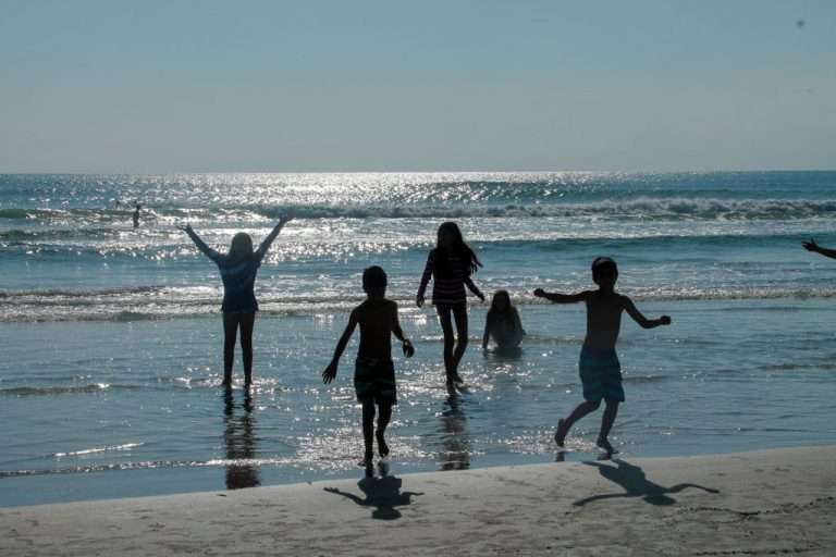 Get Everything You need for a Family Beach Vacation kids playing in ocean