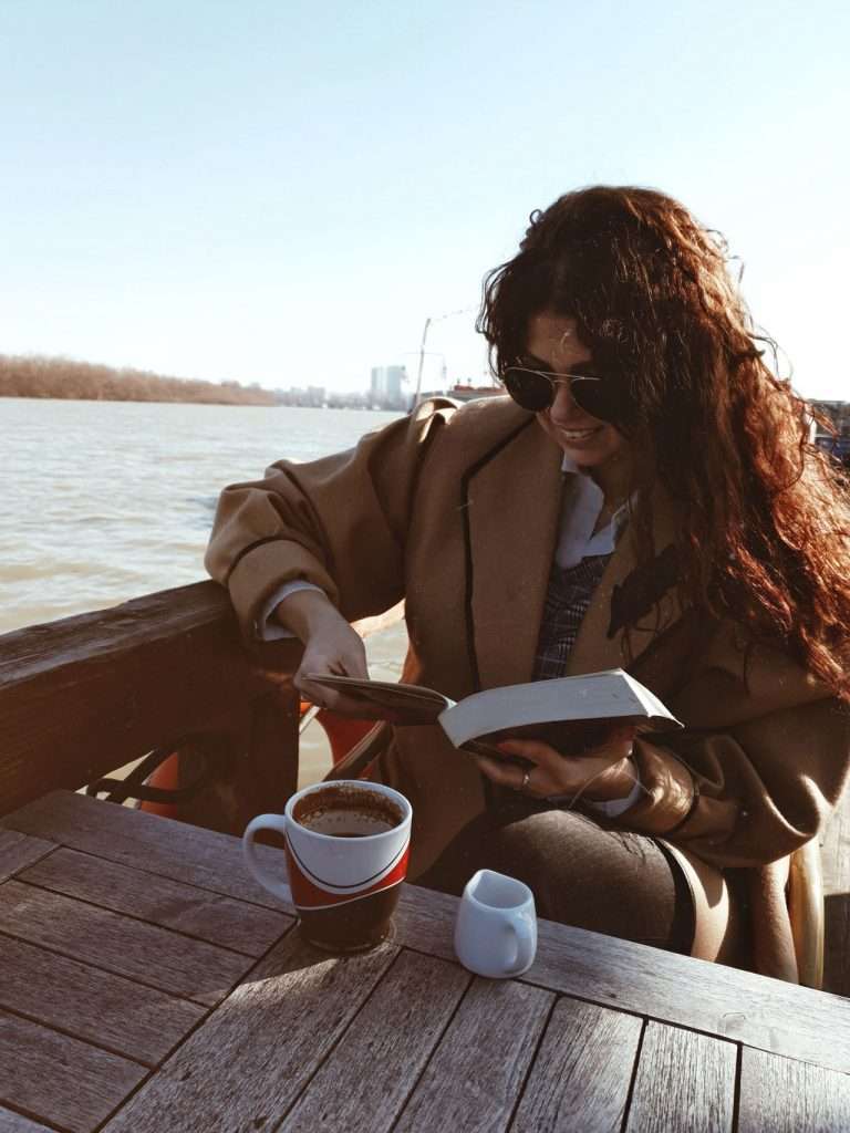 women in cafe reading travel guide books