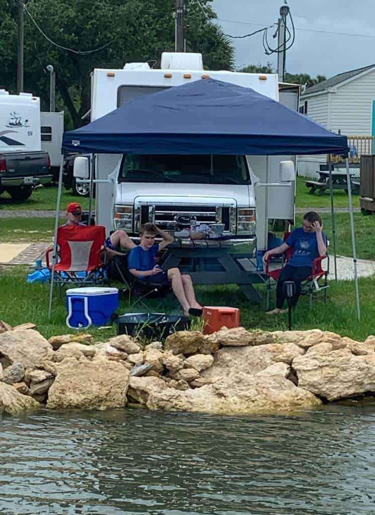 family camping in a rented RV in front of river