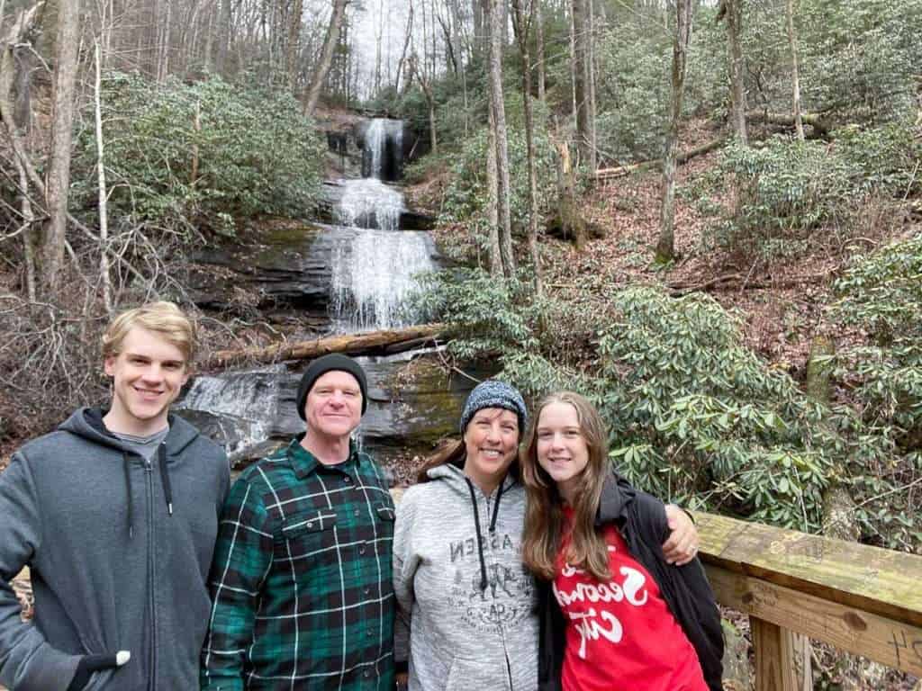 2 men and 2 women, a family, in front of DeSoto Falls in Norhtern Georgia, one of the fun things to do in Dahlonega GA with teens.