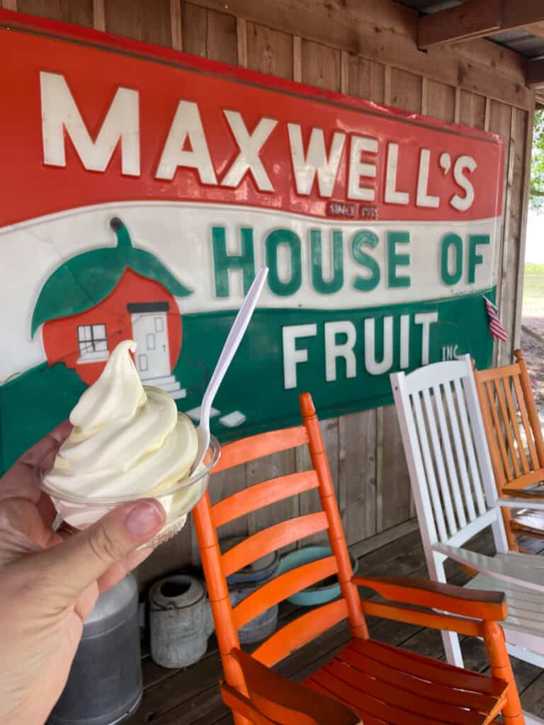orange ice cream in front of Maxwell's house of fruit sing