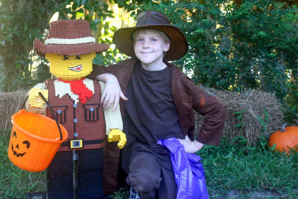 boy standing next to a Indiana Jones lego figure at LEGOLAND Halloween Travel Ideas in the US