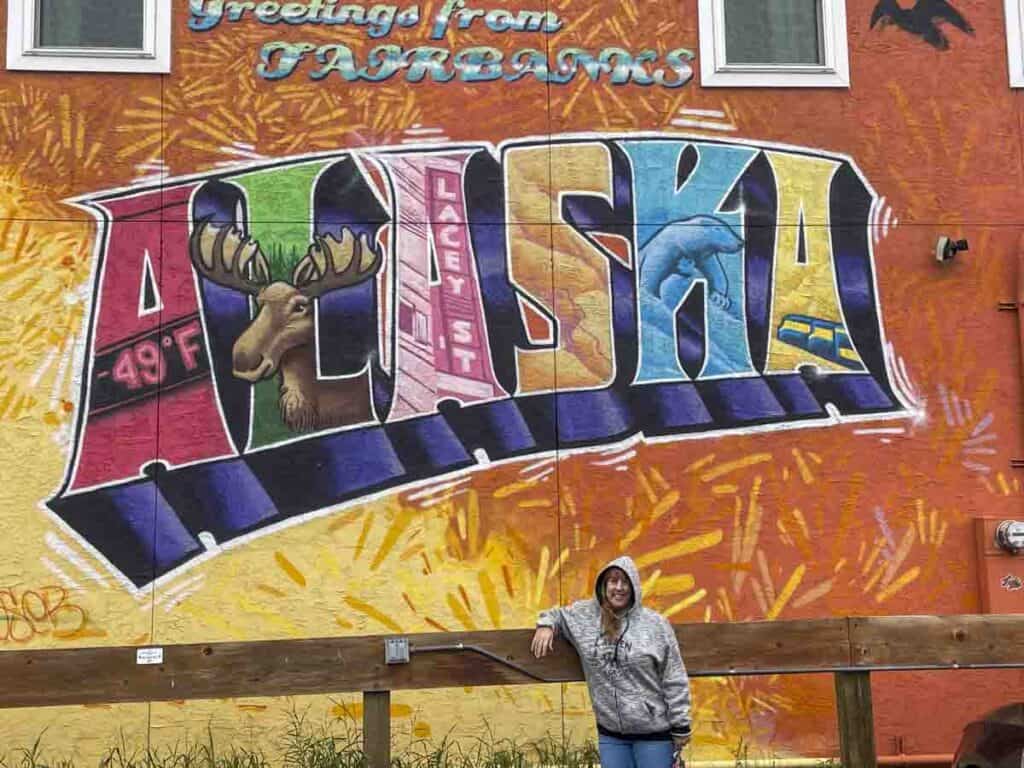 woman in front of mural of Fairbanks Alaska. Things to do in Fairbanks